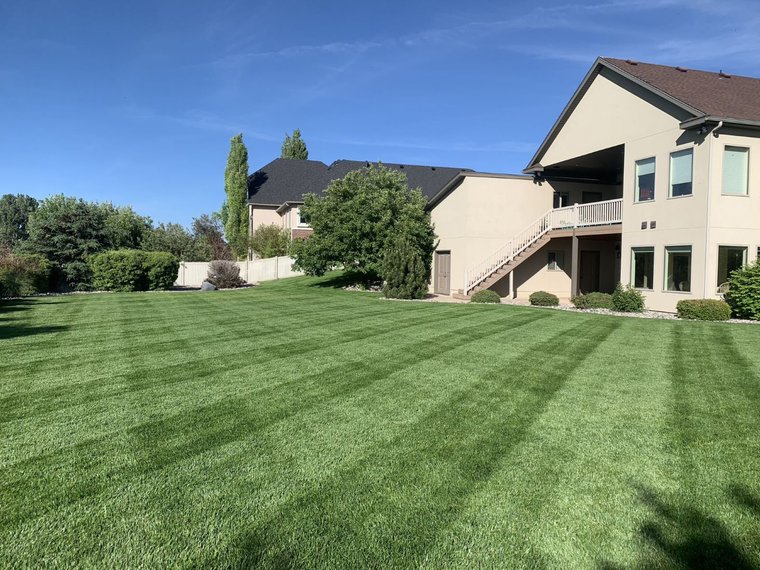 Striped green lawn maintained by J&F